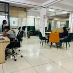 Modern coworking space in Bhopal featuring professionals working at wooden desks with ergonomic office chairs.