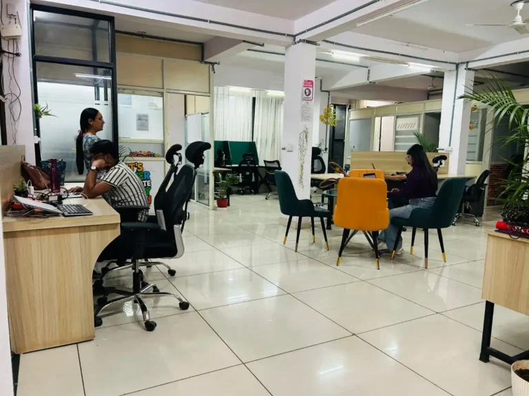 Modern coworking space in Bhopal featuring professionals working at wooden desks with ergonomic office chairs.