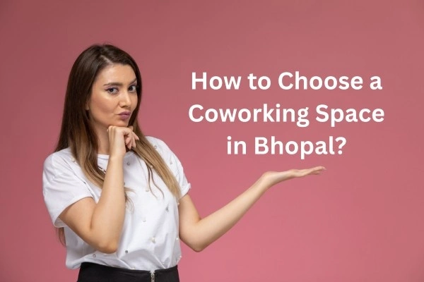 A woman in a white shirt thinking about how to choose a coworking space in Bhopal on a pink backdrop.