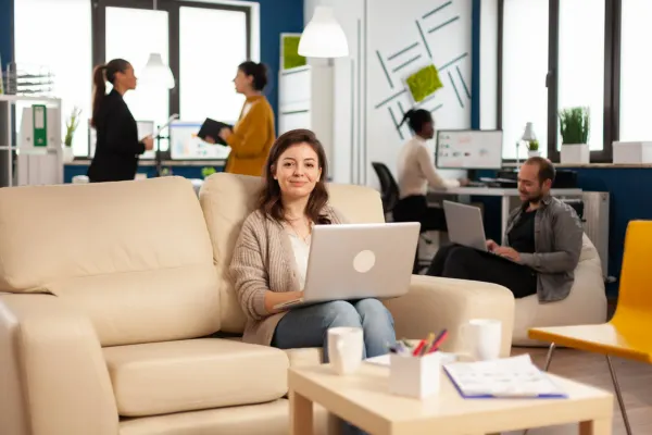 A professional woman working on her laptop in a modern, flexible coworking for startups office space.