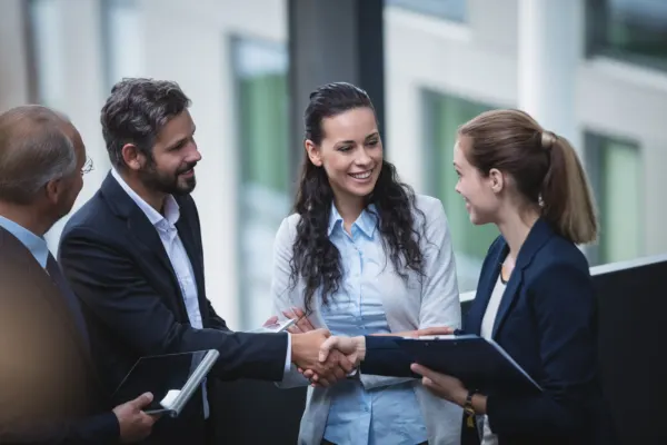 Professionals shaking hands and connecting inside a vibrant flexible coworking for startups business hub.
