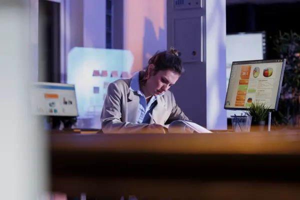 A focused professional working late at night; this modern coworking space affects productivity in positive ways.