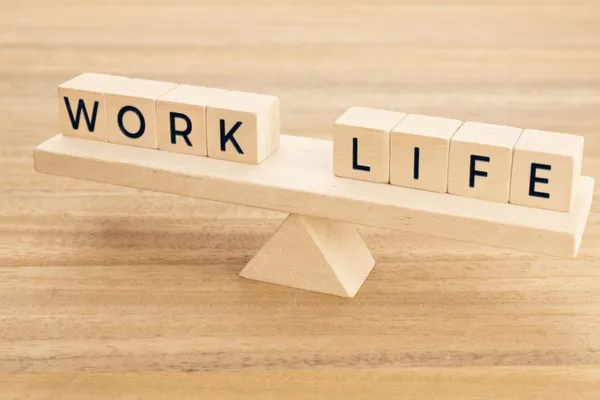 Wooden seesaw perfectly balancing work and life; the right coworking space affects productivity and balance.
