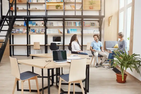Professionals collaborating in a bright shared workspace designed for teamwork, networking, productivity, and creativity.