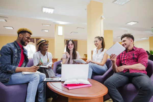 Diverse group of young professionals collaborating together to network in a coworking space lounge environment