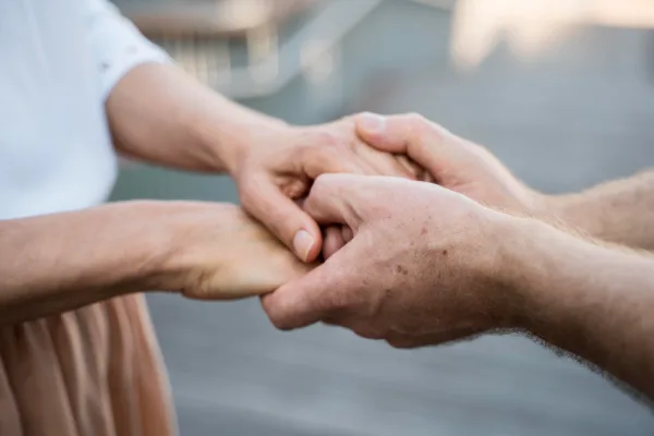 Supportive close up shot of hands offering support to build trust and network in a coworking space properly
